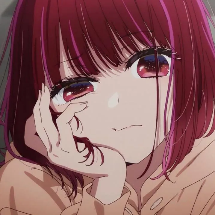 Anime PFP #49: Kana Arima with a red bob and soft red eyes rests her cheek on her hand with a small smile in a beige sweater.