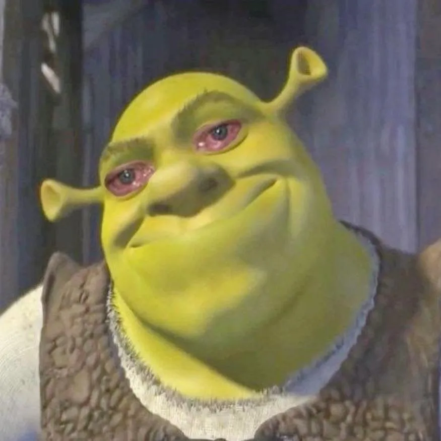 Shrek PFP #18: Shrek squints with puffy red eyes and a lopsided smirk, his head tilted, in his brown vest against a grey wooden wall.